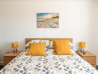 a bedroom with a bed with orange pillows at Sea Dreams in Marazion