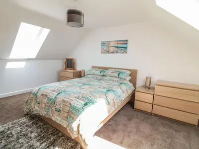 a bedroom with a bed and two night stands at Sea Dreams in Marazion