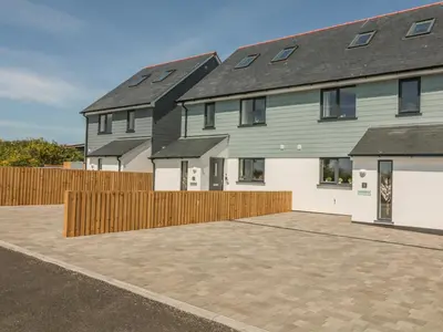 a house with a wooden fence and a driveway at Sea Dreams in Marazion