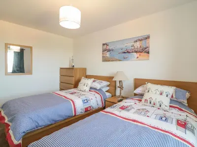 two beds sitting next to each other in a bedroom at Ocean Breeze in Marazion