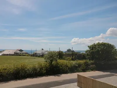 a view of a yard with houses and the ocean at Ocean Breeze in Marazion