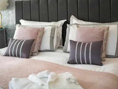a bed with a bunch of pillows on it at Be Our Guest Cottage in Truro