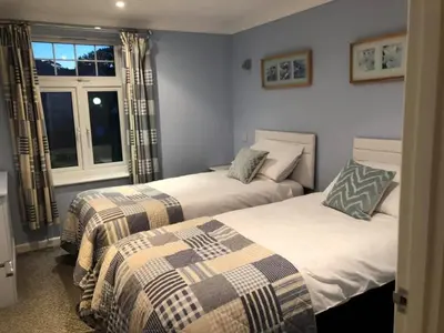 two beds in a room with a window at Atlantic Lodge in Newquay