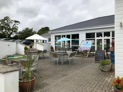 a patio with tables and chairs and a building at Atlantic Lodge in Newquay