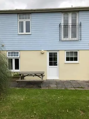 a blue and white house with a picnic table in front of it at Atlantic Lodge in Newquay