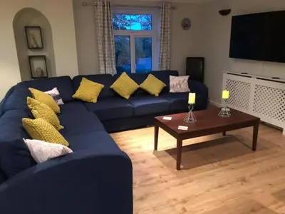 a living room with a blue couch and a coffee table at Atlantic Lodge in Newquay