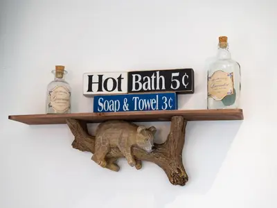 a wooden shelf with a bear and bottles on it at Bear Cottage in Truro