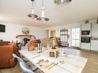 a kitchen and living room with a table and chairs at Bear Cottage in Truro
