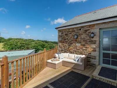 a wooden deck with a couch on top of a building at Bear Cottage in Truro
