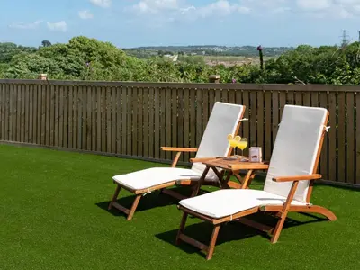 two chairs and a table on a lawn at Bear Cottage in Truro