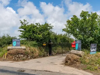 a gate with signs in front of a driveway at Bear Cottage in Truro