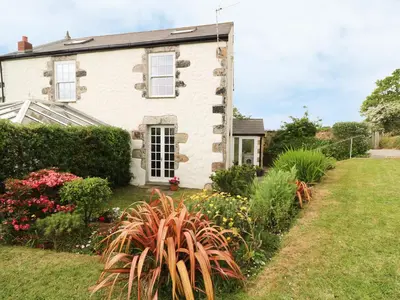 an old house with a garden in front of it at Old Chapel Cottage in Penzance
