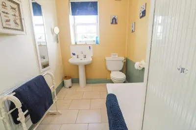 a bathroom with a toilet and a sink and a shower at Old Chapel Cottage in Penzance