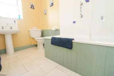 a bathroom with a tub and a sink and a toilet at Old Chapel Cottage in Penzance