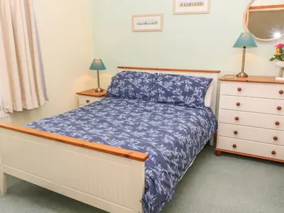 a bedroom with a bed and a dresser at Old Chapel Cottage in Penzance