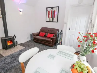 a living room with a white table and a chair at Toadstools in Penryn