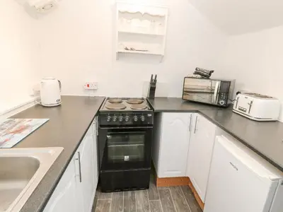 a kitchen with a black stove and a sink at Toadstools in Penryn