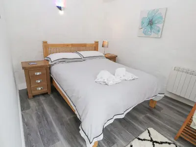 a bedroom with a large white bed and a nightstand at Toadstools in Penryn