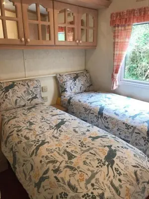 a small bedroom with a bed and a window at Countryside views from a luxury mobile home near Perranporth in Perranporth