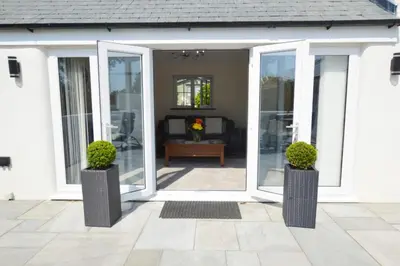 an open door of a house with two potted plants at Sunnyside Barn in Truro