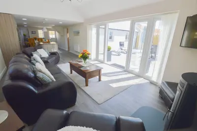 a living room with a couch and a table at Sunnyside Barn in Truro