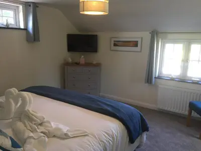 a bedroom with a bed with a tv and a dresser at Sunnyside Barn in Truro