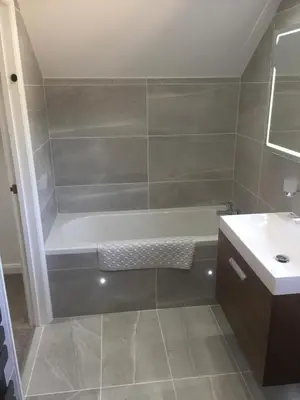a bathroom with a bath tub and a sink at Sunnyside Barn in Truro