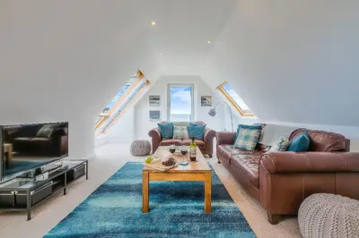 a living room with a couch and a table at Trevail Penthouse in St Ives