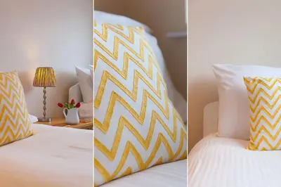 two pictures of a bed with a yellow and white pillow at Trevail Penthouse in St Ives