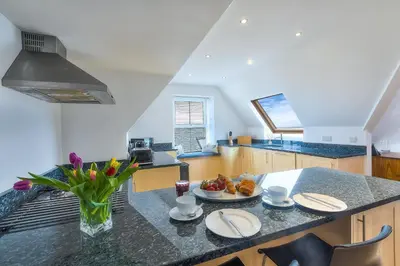a kitchen with a table with a plate of food on it at Trevail Penthouse in St Ives