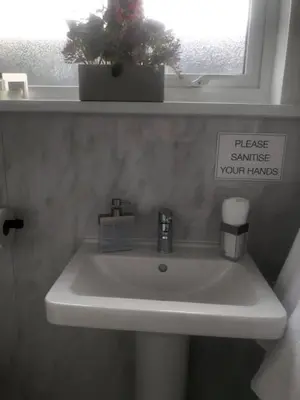 a bathroom sink with a sign that reads please estimate your tanks at Alderberry Lodge in Newquay