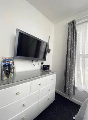a white dresser with a television on top of it at Alderberry Lodge in Newquay