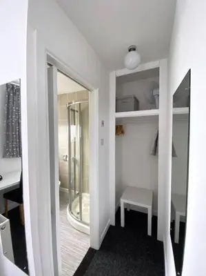 a room with a mirror and a table and a shower at Alderberry Lodge in Newquay
