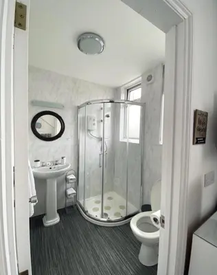 a bathroom with a shower and a toilet and a sink at Alderberry Lodge in Newquay