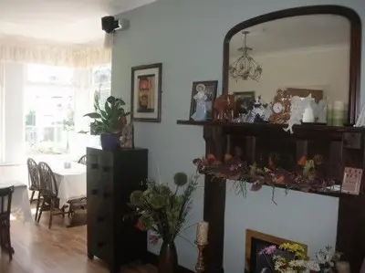 a living room with a mirror and a table at Alderberry Lodge in Newquay