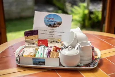 a tray of food and cups on a table at Cornish Holiday - Meadow Rise in Saint Columb Major