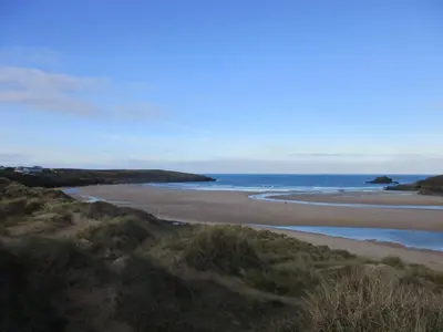a sandy beach with the ocean in the background at Cornish Holiday - Meadow Rise in Saint Columb Major
