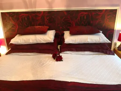 a bedroom with two beds with red and white pillows at Arches B&B in St Austell