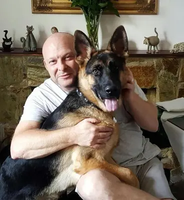 a man is holding a dog on his lap at Arches B&B in St Austell