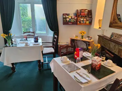 a dining room with two tables and two chairs at Arches B&B in St Austell