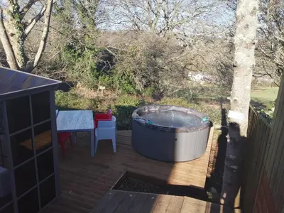 a hot tub on a deck next to a table at So Tranquil in Charlestown