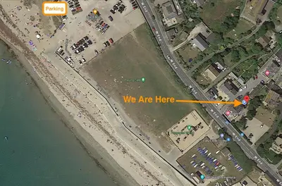 a map of a road with a sign that says we are here at Sandpiper, apartment across from the beach in Marazion