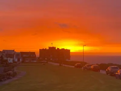 a sunset over a parking lot with cars parked at Buena Vista in Tintagel