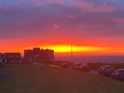 a sunset with cars parked in a parking lot at Buena Vista in Tintagel