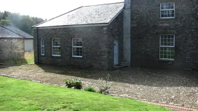 a brick house with a grass yard in front of it at Waterfall Cottage in Launceston