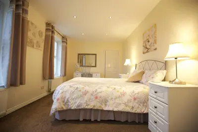 a bedroom with a bed and a lamp and a dresser at Waterfall Cottage in Launceston