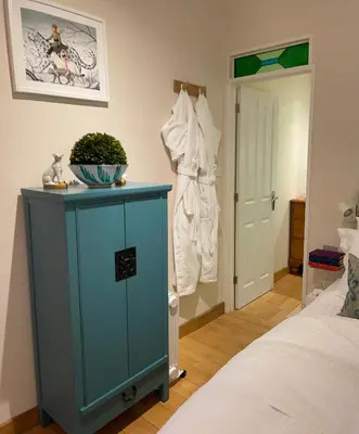 a bedroom with a blue cabinet next to a bed at THE HYDE- secret hide away, near the beach. in Truro