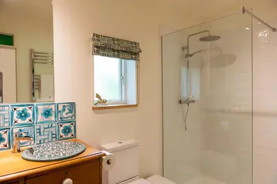 a bathroom with a glass shower and a toilet at THE HYDE- secret hide away, near the beach. in Truro