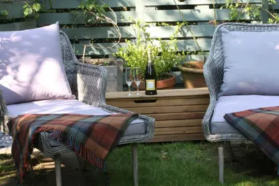 two wicker chairs and a table with a bottle of wine at THE HYDE- secret hide away, near the beach. in Truro