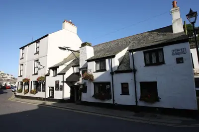 a white building on the side of a street at Polmear Harbour View With Terrace in Looe